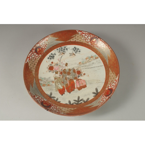 1064 - A JAPANESE KUTANI PORCELAIN CHARGER, painted with a central panel of figures and heightened with gil... 