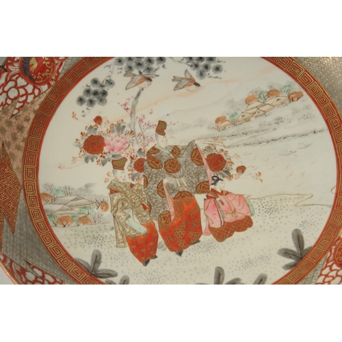 1064 - A JAPANESE KUTANI PORCELAIN CHARGER, painted with a central panel of figures and heightened with gil... 