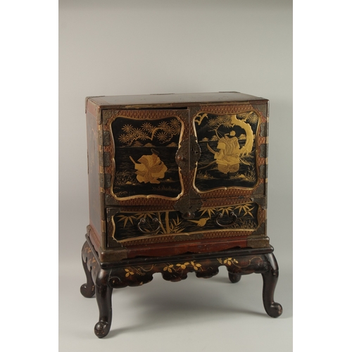 1060 - A FINE JAPANESE MEIJI PERIOD BLACK AND GILT LACQUERED CABINET, raised on stand, the two doors openin... 