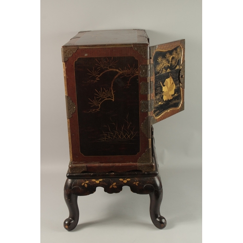 1060 - A FINE JAPANESE MEIJI PERIOD BLACK AND GILT LACQUERED CABINET, raised on stand, the two doors openin... 