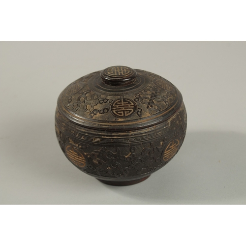 1071 - A CHINESE CARVED COCONUT LIDDED BOX, carved with longevity symbols and precious objects, 11.5cm diam... 