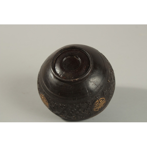 1071 - A CHINESE CARVED COCONUT LIDDED BOX, carved with longevity symbols and precious objects, 11.5cm diam... 