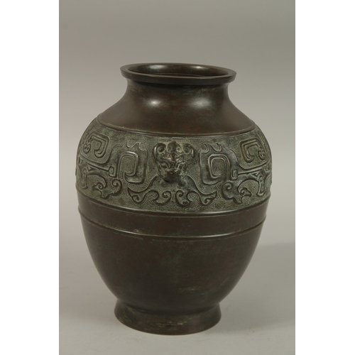 1216 - A CHINESE BRONZE TWIN HANDLE VASE, with relief band of archaic decoration, 23cm high.