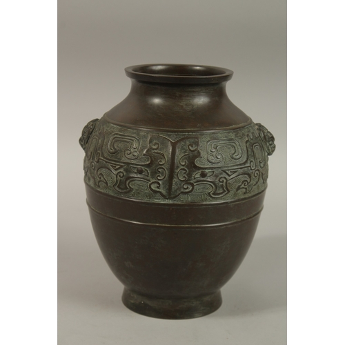 1216 - A CHINESE BRONZE TWIN HANDLE VASE, with relief band of archaic decoration, 23cm high.