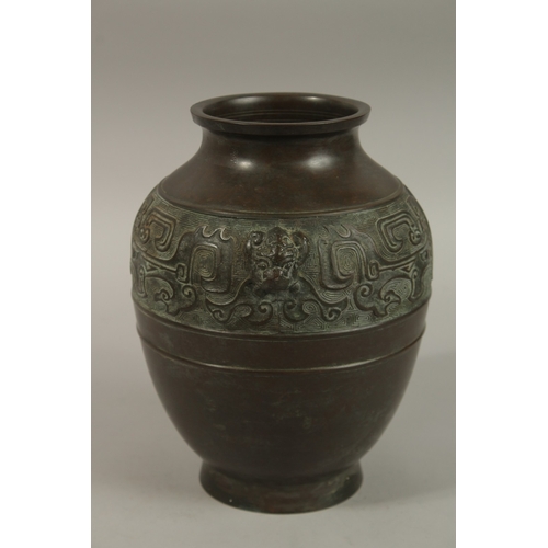 1216 - A CHINESE BRONZE TWIN HANDLE VASE, with relief band of archaic decoration, 23cm high.