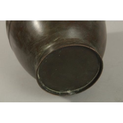 1216 - A CHINESE BRONZE TWIN HANDLE VASE, with relief band of archaic decoration, 23cm high.