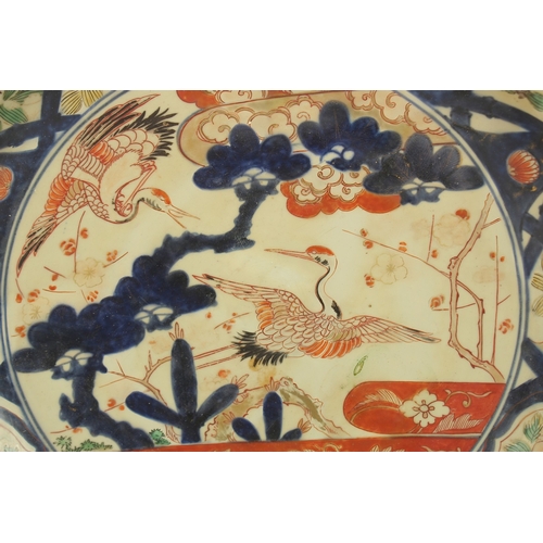 1289 - A VERY LARGE 19TH CENTURY JAPANESE IMARI PORCELAIN CHARGER, painted with a central panel of cranes a... 