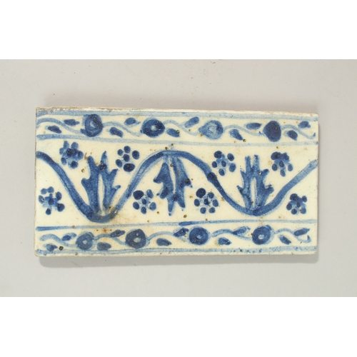 127 - A RARE 18TH CENTURY TURKISH OTTOMAN KUTAHYA GLAZED POTTERY BORDER TILE, 20cm x 10cm.