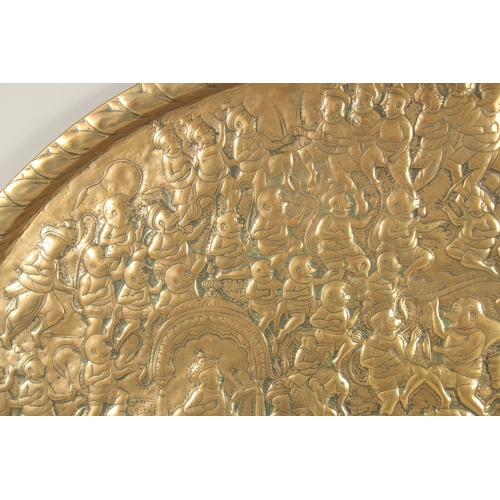 137 - A LARGE 19TH CENTURY NORTH INDIAN EMBOSSED BRASS TRAY, depicting a battle scene from the Ramayana wi... 