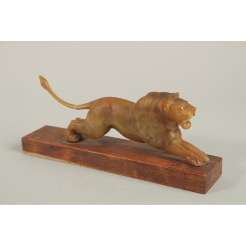 143 - A PAIR OF 19TH CENTURY INDIAN CARVED HORN LIONS ON WOODEN STANDS, 20cm long (excl. base).