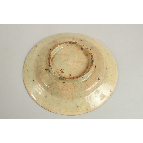 152 - AN EARLY PERSIAN GLAZED POTTERY DISH, painted with foliate designs, 19cm diameter.