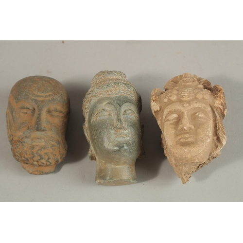 157 - A GROUP OF THREE INDIAN GANDHARA CARVED HEADS, buddha 9.5cm high, (3).