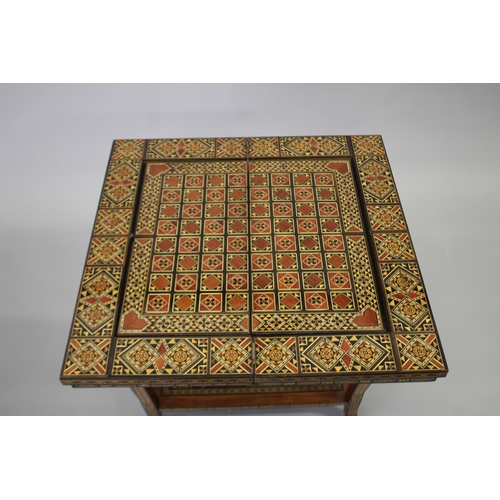 166 - A MOROCCAN MARQUETRY INLAID FOLDING GAMES TABLE, with open-out inset top and folding out leg.