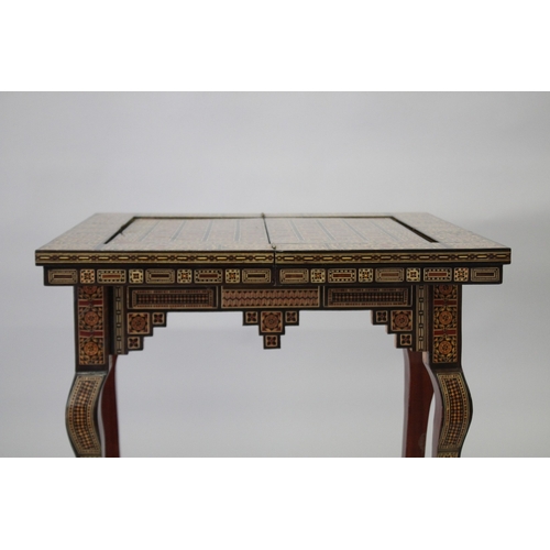 166 - A MOROCCAN MARQUETRY INLAID FOLDING GAMES TABLE, with open-out inset top and folding out leg.