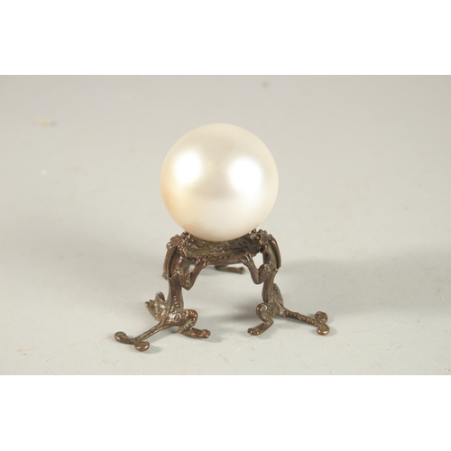 209 - A PEARLESCENT SPHERICAL ORNAMENT ON A BRONZE STAND, the stand formed with tripod chilong legs.