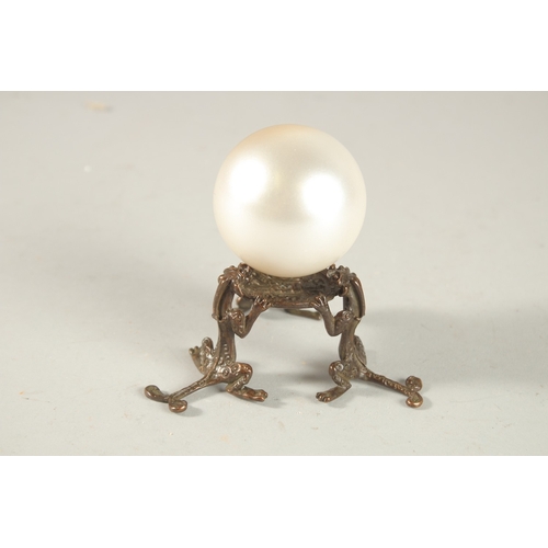 209 - A PEARLESCENT SPHERICAL ORNAMENT ON A BRONZE STAND, the stand formed with tripod chilong legs.