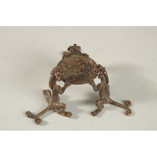 209 - A PEARLESCENT SPHERICAL ORNAMENT ON A BRONZE STAND, the stand formed with tripod chilong legs.