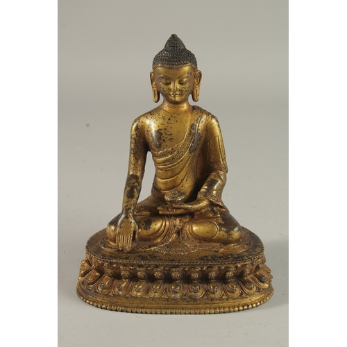 233 - A TIBETAN GILT BRONZE SEATED BUDDHA ON LOTUS BASE, 20cm high.