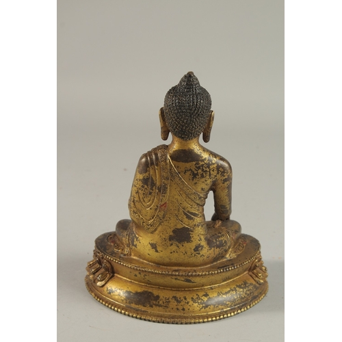 233 - A TIBETAN GILT BRONZE SEATED BUDDHA ON LOTUS BASE, 20cm high.