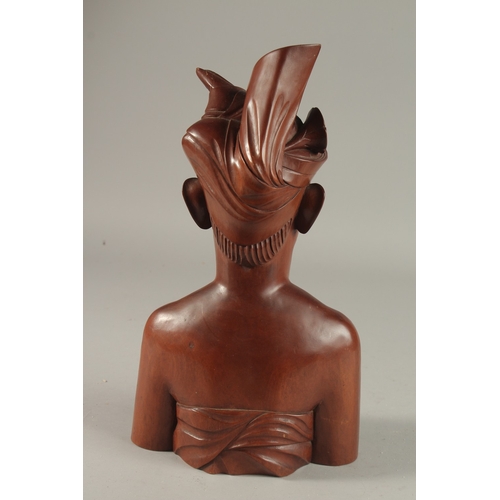 261 - A FINELY CARVED BALINESE BUST OF A MAN, 34cm high.