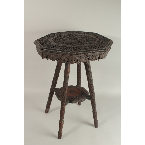 263 - A 19TH CENTURY KASHMIRI CARVED WOOD TABLE, with octagonal top carved with foliate scrolls, 60cm high... 