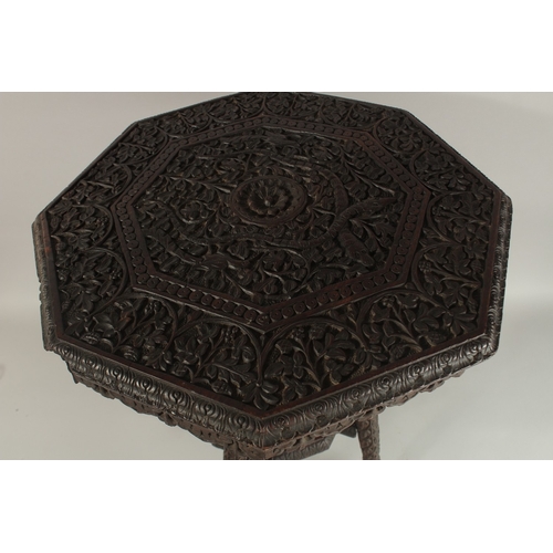 263 - A 19TH CENTURY KASHMIRI CARVED WOOD TABLE, with octagonal top carved with foliate scrolls, 60cm high... 