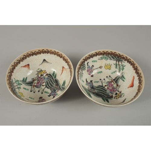 27 - A PAIR OF CHINESE PORCELAIN BOWLS, painted with figures on horseback, 15cm diameter.