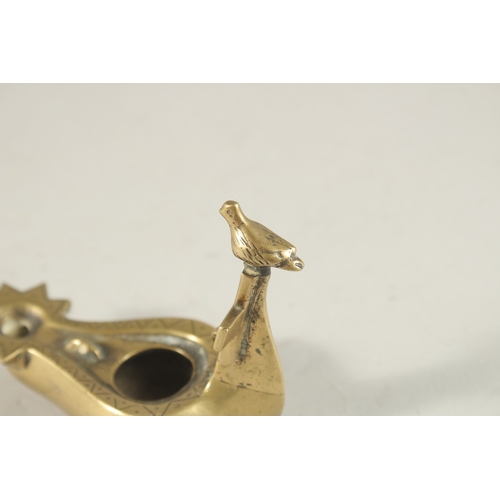 270 - A BRASS OIL LAMP WITH CROSS AND BIRD HANDLE, 10.5cm long.