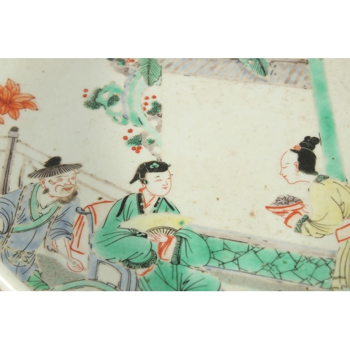 299 - A CHINESE FAMILLE VERTE PORCELAIN DISH, painted with figures in a courtyard, 27cm diameter.