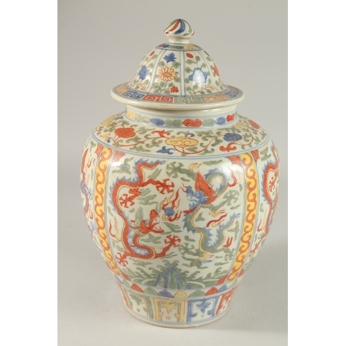 300 - A CHINESE WUCAI PORCELAIN GINGER JAR AND COVER, painted with dragons and floral motifs, 35cm high.