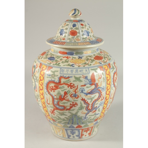 300 - A CHINESE WUCAI PORCELAIN GINGER JAR AND COVER, painted with dragons and floral motifs, 35cm high.