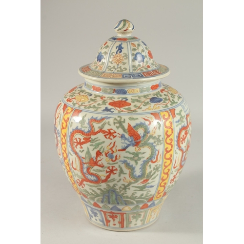 300 - A CHINESE WUCAI PORCELAIN GINGER JAR AND COVER, painted with dragons and floral motifs, 35cm high.