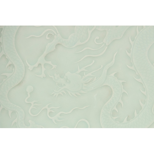 301 - A LARGE CHINESE CELADON GLAZE CARVED DRAGON CHARGER, with petal-form rim, 44cm wide.