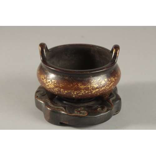 309 - A CHINESE GOLD SPLASH BRONZE TWIN HANDLE CENSER, on hardwood stand, with six-character mark to base,... 