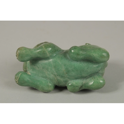 33 - A CHINESE CARVED GREEN HARDSTONE DOG OF FO, 8cm long.