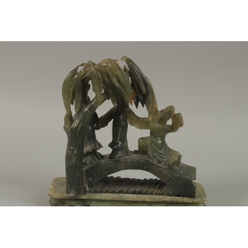 41 - A LARGE CHINESE CARVED JADE GROUP, depicting three figures on a bridge beneath a tree, together with... 