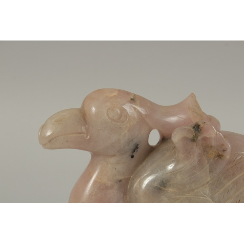 42 - A LARGE CHINESE CARVED ROSE QUARTZ FIGURE OF A BIRD, on a carved hardwood stand, quartz 20cm long.