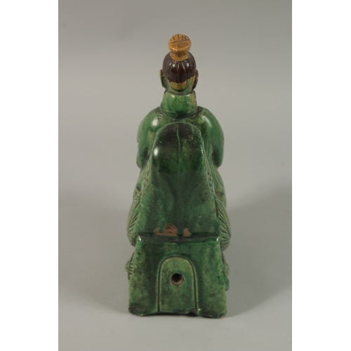 51 - A CHINESE GREEN AND YELLOW GLAZED POTTERY FIGURE of a man on a mythical bird, 22cm high.