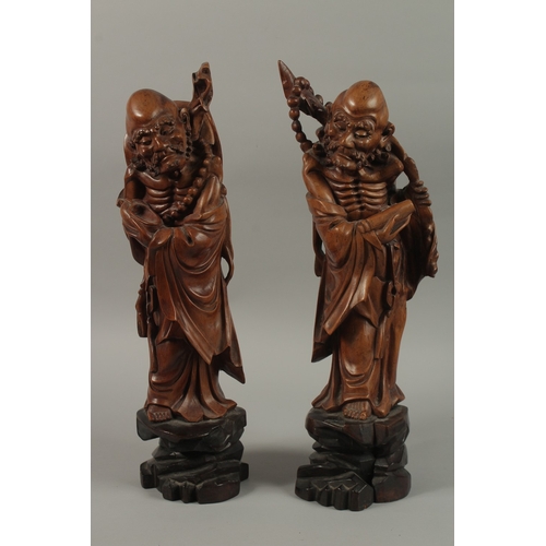 54 - A VERY FINE PAIR OF CHINESE CARVED HARDWOOD FIGURES, with inset bead eyes, 45cm high.