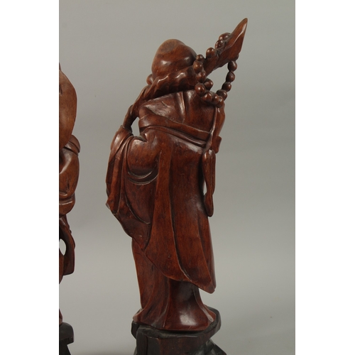 54 - A VERY FINE PAIR OF CHINESE CARVED HARDWOOD FIGURES, with inset bead eyes, 45cm high.