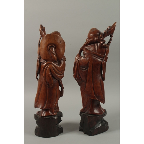 54 - A VERY FINE PAIR OF CHINESE CARVED HARDWOOD FIGURES, with inset bead eyes, 45cm high.