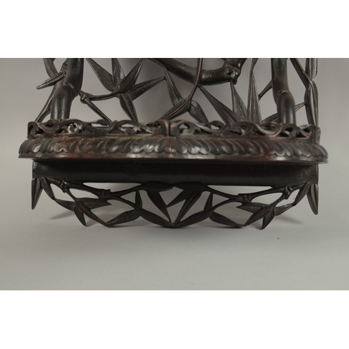 60 - A CHINESE CARVED OPENWORK HARDWOOD WALL SHELF, carved with bamboo tree design, 46cm high.