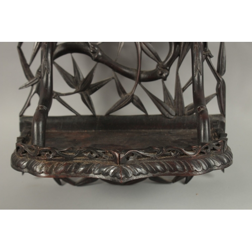 60 - A CHINESE CARVED OPENWORK HARDWOOD WALL SHELF, carved with bamboo tree design, 46cm high.