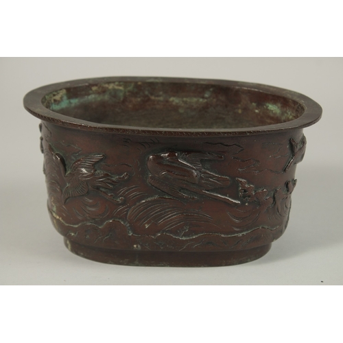 65 - A BRONZE OVAL FORM JARDINIERE, with relief decoration of cranes, the base with character mark, 22cm ... 