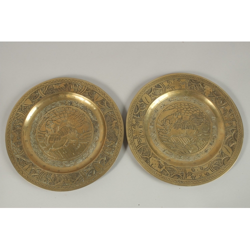 69 - A PAIR OF CHINESE ENGRAVED AND CHASED BRASS DISHES, with central dog of fo, the bases with character... 