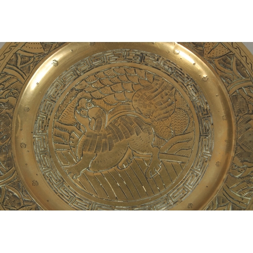 69 - A PAIR OF CHINESE ENGRAVED AND CHASED BRASS DISHES, with central dog of fo, the bases with character... 