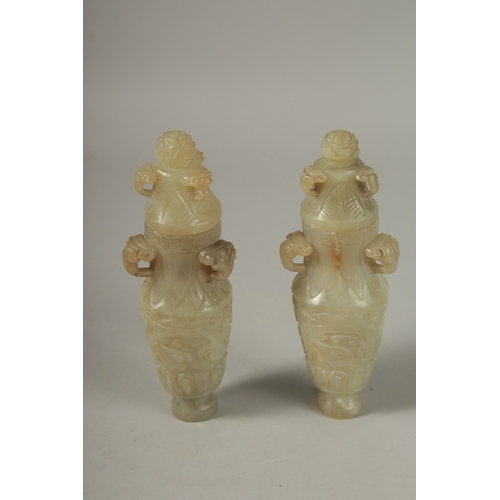 93 - A PAIR OF 18TH CENTURY CARVED JADE VASES AND COVERS, with ram mask handles and carved scrolls, 19cm ... 