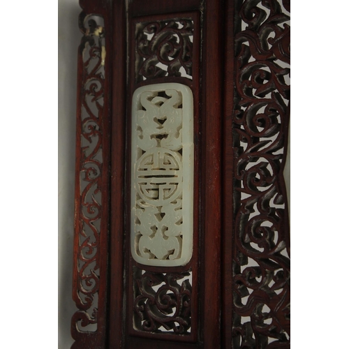 94 - A PAIR OF SHAPED JADE PLAQUES INSET WITHIN A HARDWOOD FRAME, creating a carved wood table screen, he... 