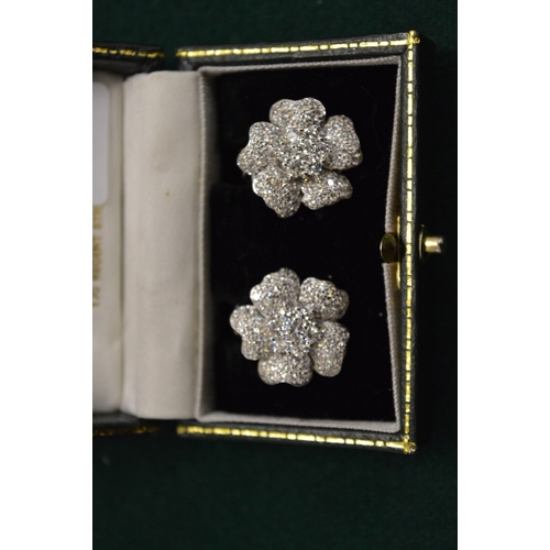 1020A - A pair of 18ct white gold and diamond flower head ear clips.