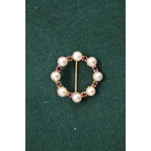 1034 - A 9ct gold pearl and garnet circular brooch.